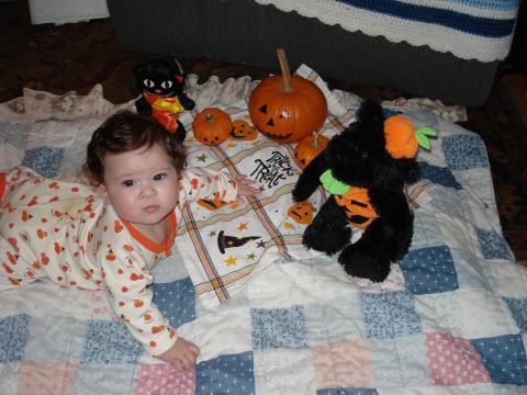 2000 Ford Crown Victoria - A baby is surrounded by Halloween-themed decorations on a quilt.