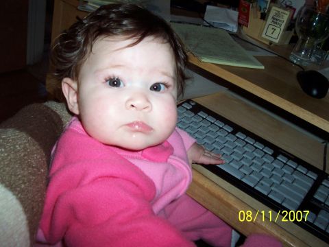 2000 Ford Crown Victoria - A baby in pink sits at a desk, looking at the camera with a keyboard in front of them. The photo is dated August 11, 2007.
