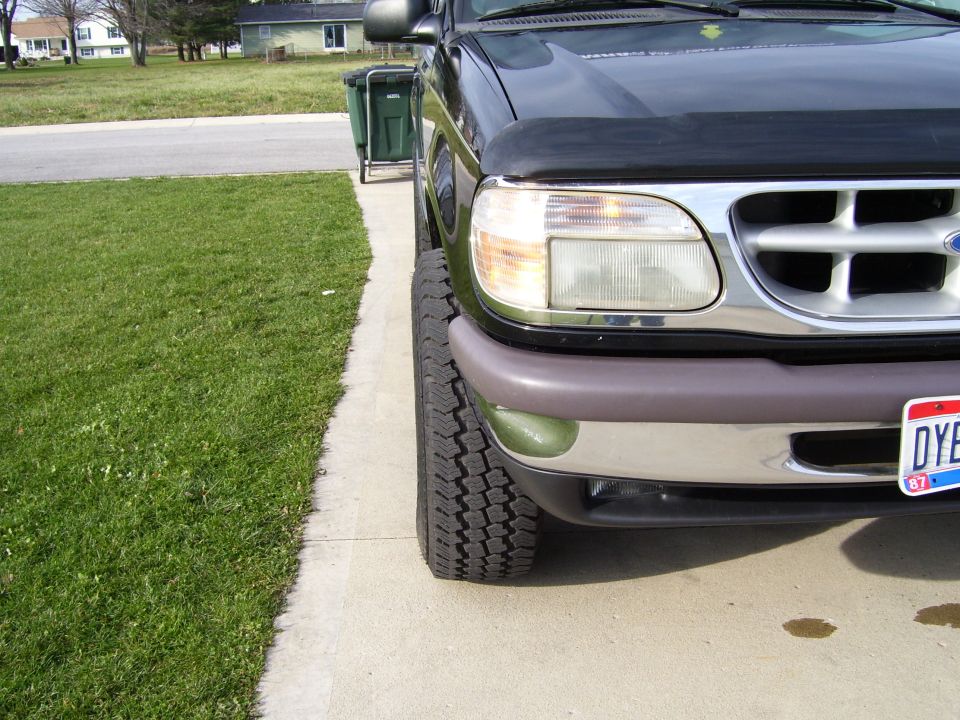 Front corner of a black Ford Explorer with a gray bumper and a license plate