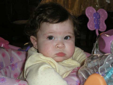 2000 Ford Crown Victoria - A baby with dark curly hair sits in a seat with toys around them.
