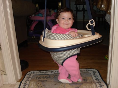 2000 Ford Crown Victoria - Baby in a jumper seat, with a playpen and furniture in the background.