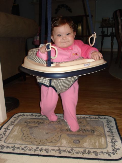 2000 Ford Crown Victoria - A baby is enjoying time in a jumper, with a rug beneath their feet.