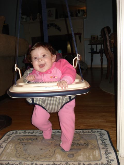 2000 Ford Crown Victoria - A smiling baby is in a walker, supported by straps and a tray.