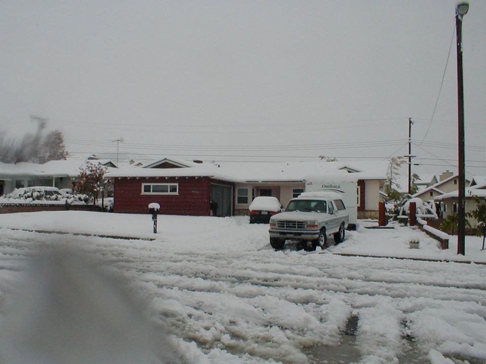 White 1996 Ford Bronco parked in snow with a trailer