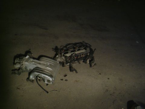 2001 Dodge 2500 - Engine components are disassembled and resting on a paved surface.