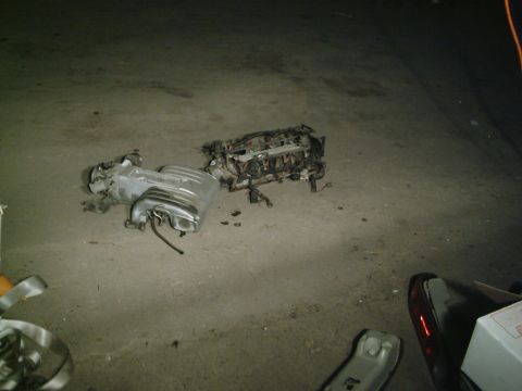 2001 Dodge 2500 - Engine components are laid out on a concrete surface, with visible wiring and metal parts.