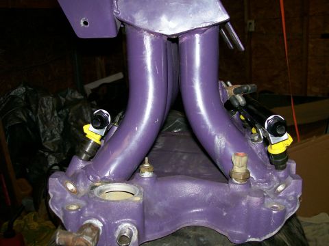 1988 Ford Bronco - Close-up of a purple-painted intake manifold with fuel injectors installed, likely for an engine rebuild or upgrade.