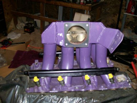 1988 Ford Bronco - A purple intake manifold with fuel injectors and a fuel rail is shown, likely a vehicle part.