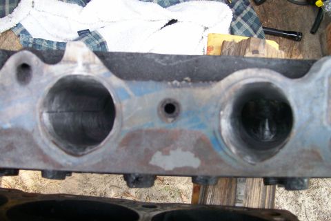1988 Ford Bronco - Close-up of an engine cylinder head, showing intake ports and a central bolt hole.