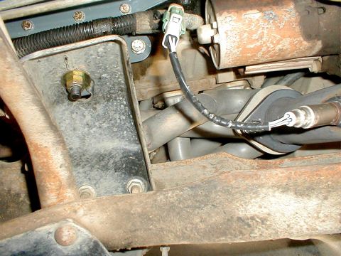 1996 Ford Bronco - This image shows a close-up view of the exhaust manifold and an oxygen sensor, part of a vehicle's exhaust system.