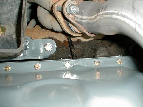 1996 Ford Bronco - Close-up view of vehicle undercarriage components, including an exhaust pipe and oil pan.