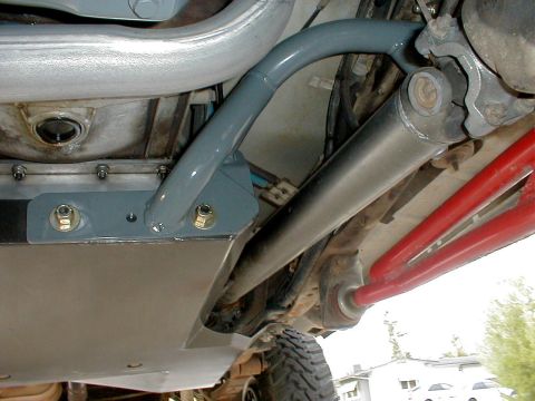 1996 Ford Bronco - Close-up of the undercarriage reveals custom suspension parts and a protective skid plate, suggesting off-road modifications.