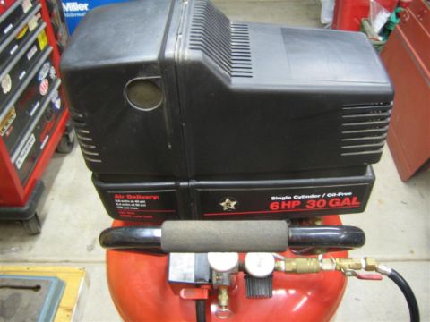 1994 Ford Bronco - A black air compressor with a red tank is shown, a 6HP 30 GAL label and gauges.