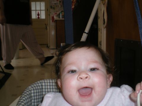 2000 Ford Crown Victoria - A baby sits in a high chair, looking at the camera with a wide smile and open mouth.