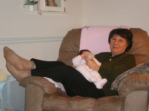 2000 Ford Crown Victoria - A woman is seated in a recliner, feeding a baby with a bottle.