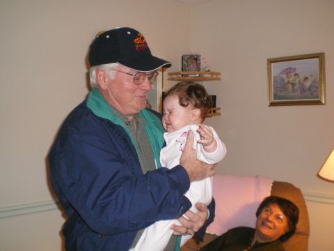 2000 Ford Crown Victoria - A man holds a crying baby while a woman watches from a chair.