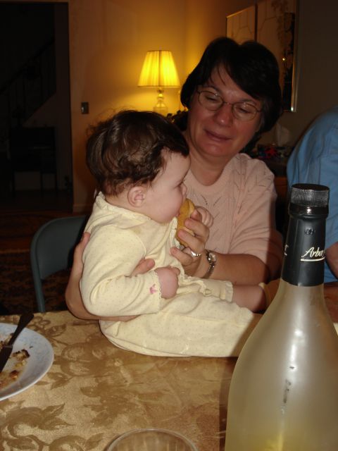 2000 Ford Crown Victoria - A woman holds a baby while feeding it at a table.