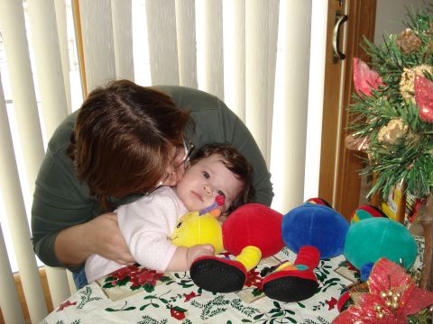 2000 Ford Crown Victoria - A tender moment captured between a woman and a baby, with festive decorations in the background.