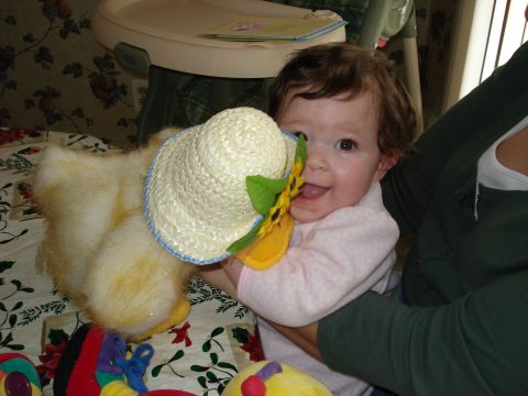 2000 Ford Crown Victoria - A smiling baby plays with a stuffed duck toy while sitting in a high chair.