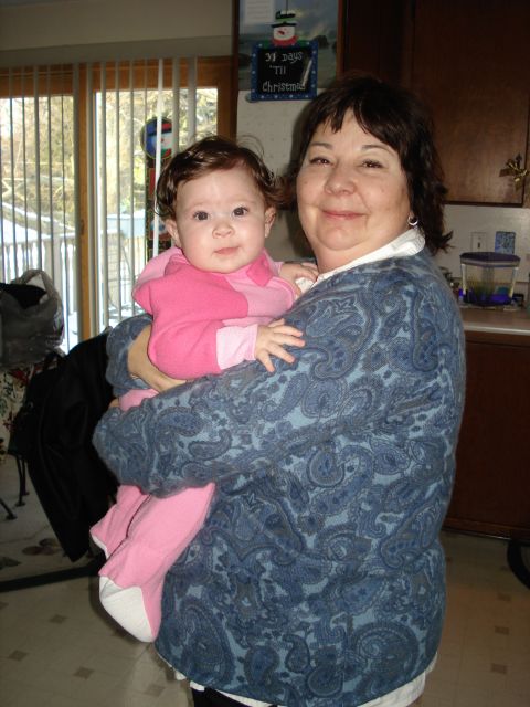 2000 Ford Crown Victoria - A woman holds a baby in a pink outfit in a home environment.
