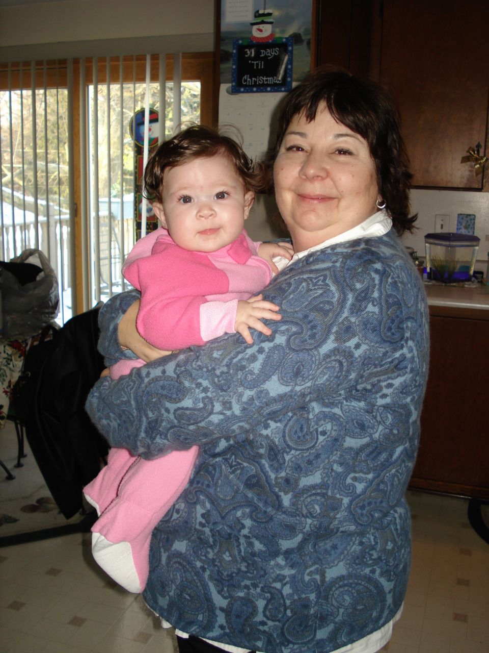 Woman holding a baby in a pink outfit indoors