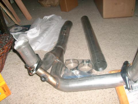 1989 Ford Bronco - Aftermarket exhaust Y-pipe and extension pipe laid out on carpet.