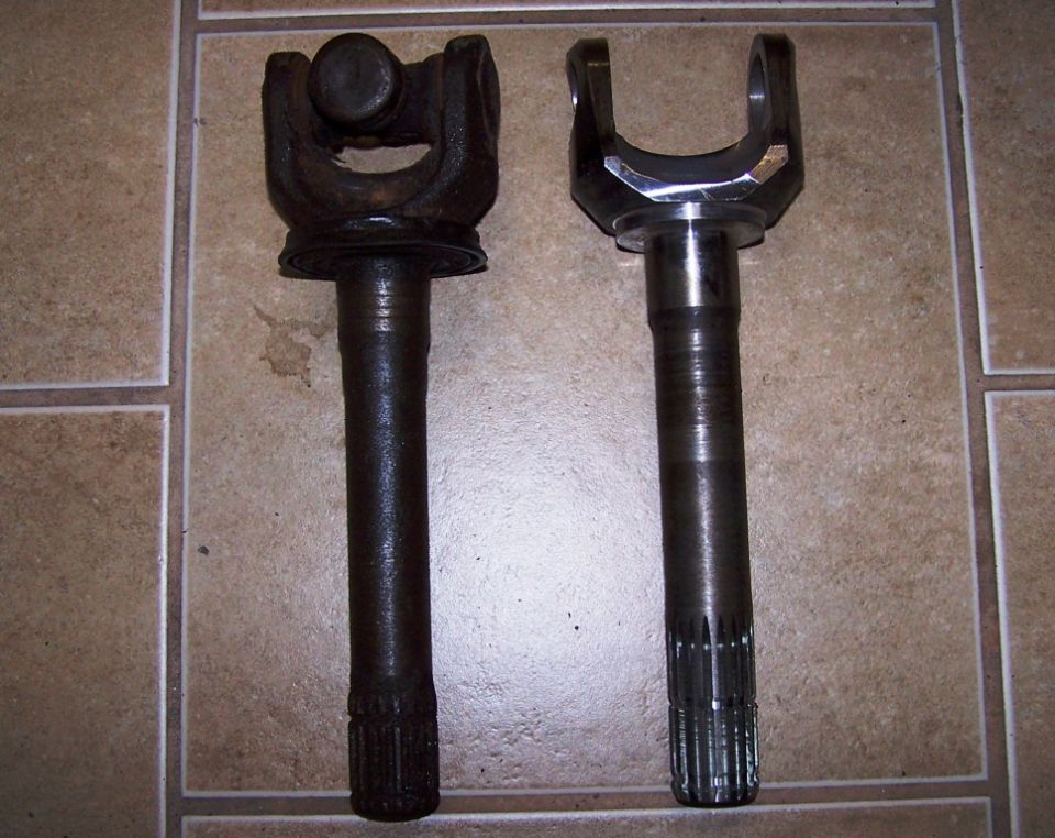 Old rusty driveshaft yoke next to a new shiny one
