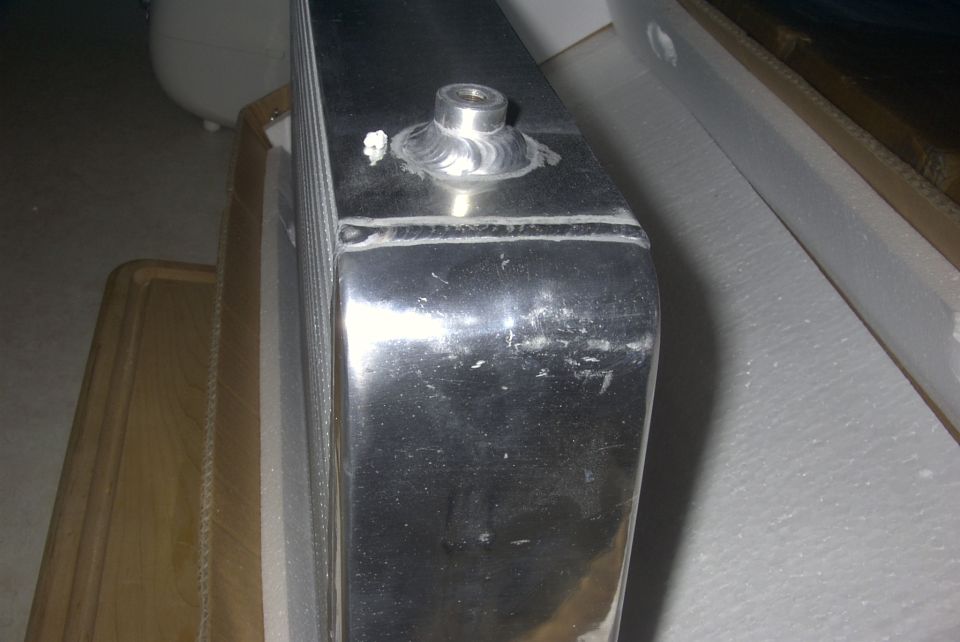 Polished aluminum tank with TIG welds and threaded bung on foam packing