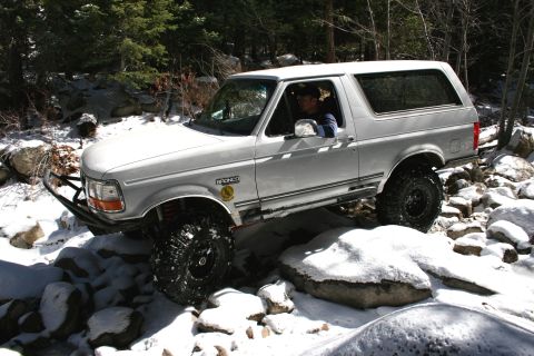 1996 Ford Bronco - This 1996 Ford Bronco is shown off-roading through a snowy, rocky landscape.