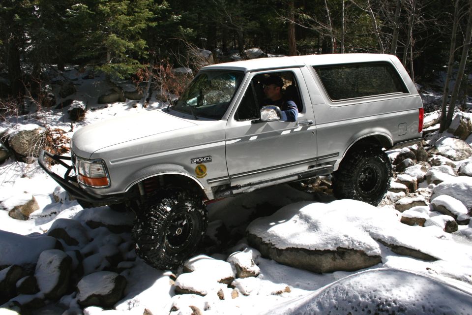 White 1996 Ford Bronco navigating rocky, snowy terrain