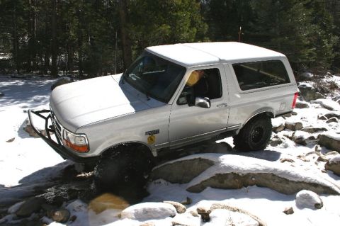 1996 Ford Bronco - A 1996 Ford Bronco navigates a snowy, rocky trail.