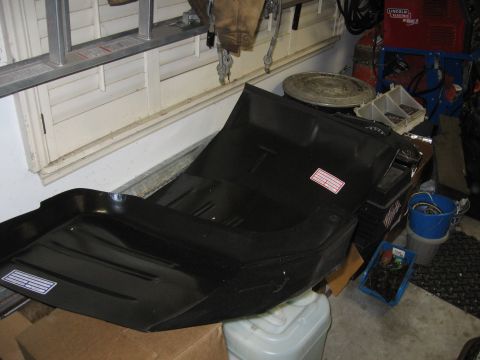 1979 Ford F-150 - Black metal floor pan with two white labels, seen in a garage setting.