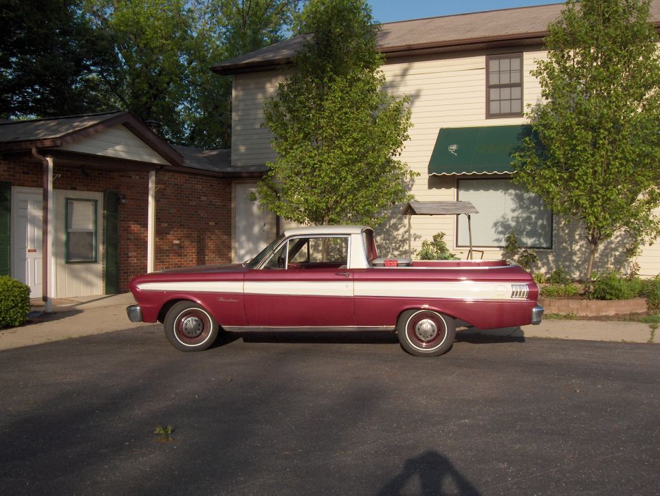 Maroon Ford Ranchero with white roof and side stripe, side view, parked in front of a building
