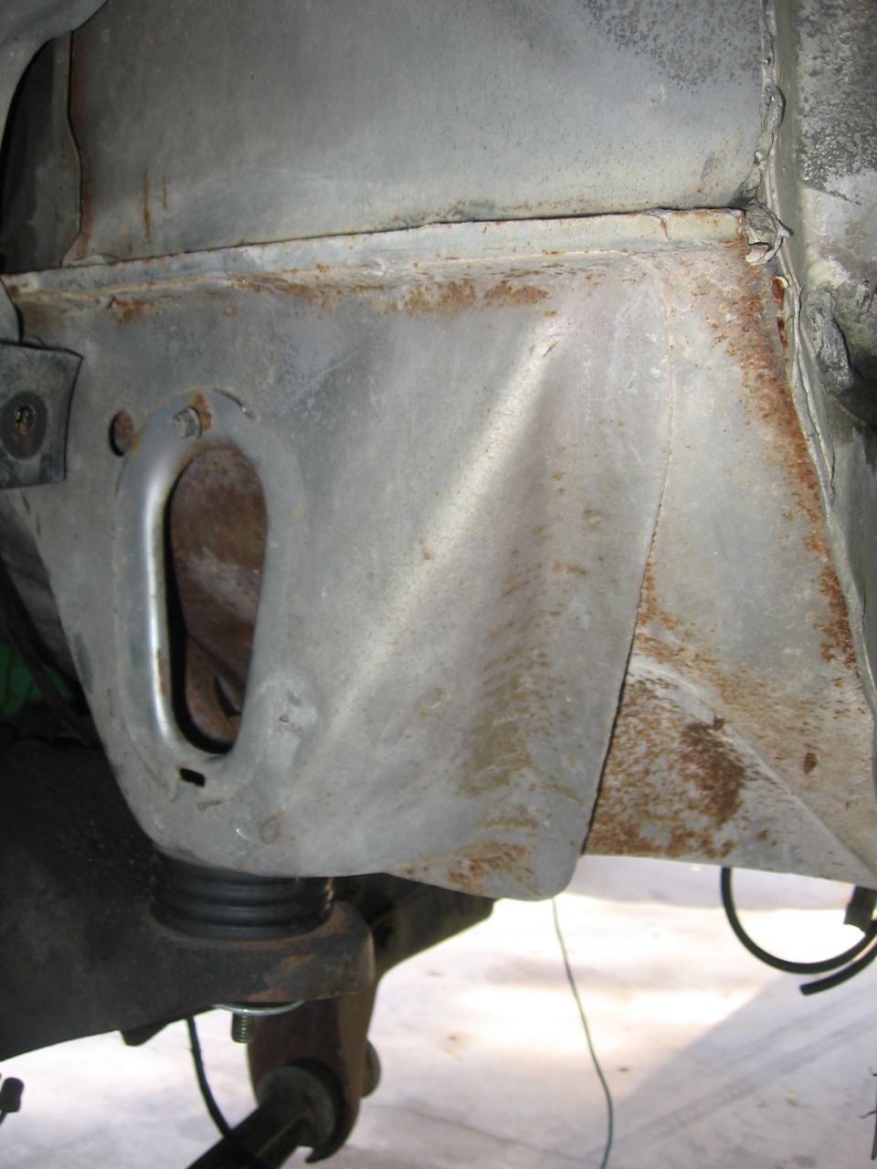 Close-up of rusted metal frame and suspension parts under a vehicle