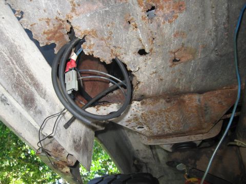 1979 Ford F-150 - The undercarriage of a vehicle shows significant rust damage and exposed wiring.