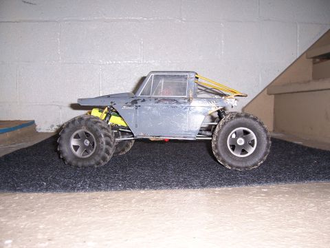 1996 Ford Bronco - A radio-controlled car resembling a classic SUV sits on a dark mat in front of a concrete wall.