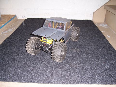 1996 Ford Bronco - This remote control monster truck is sitting on a dark gray carpeted surface.