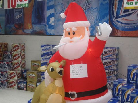 1996 Ford Bronco - An inflatable Santa and Rudolph are displayed in front of stacks of beer, with a humorous note attached to Santa.