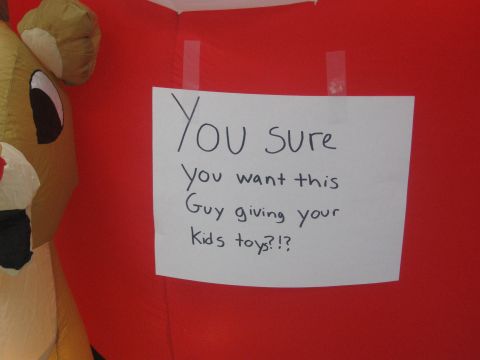 1996 Ford Bronco - A handwritten sign questions the appropriateness of an inflatable reindeer giving toys to children.