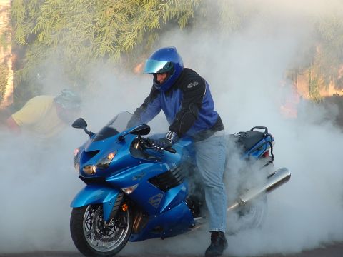 2007 Kawasaki Ninja - Motorcyclist performs a burnout on a blue 2007 Kawasaki Ninja, creating a large cloud of smoke.