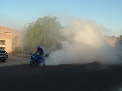 2007 Kawasaki Ninja - A motorcycle rider performs a burnout in a residential area, creating a large cloud of smoke.