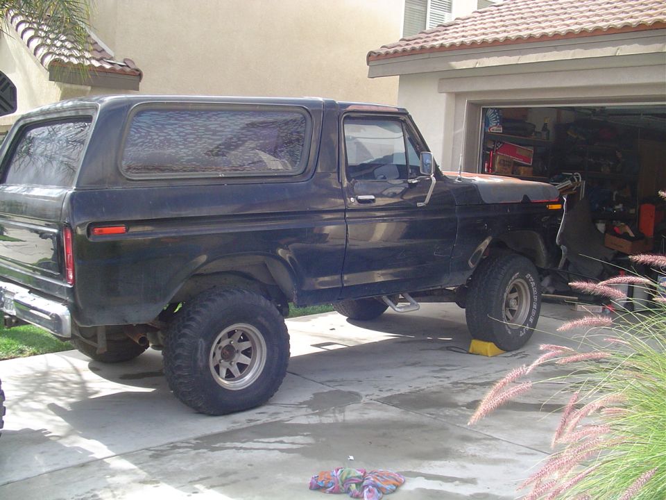 Side view of a black 1978 Ford Bronco parked in a driveway