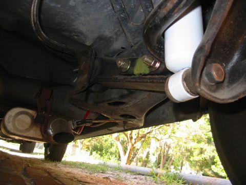 1985 Ford Crown Victoria LTD - A close-up view of the undercarriage reveals suspension parts and the exhaust system, with a SuperMotors watermark visible.