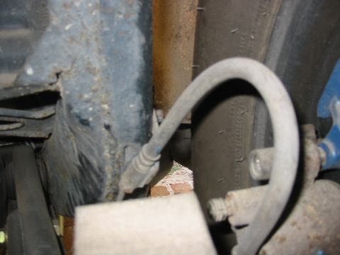 1985 Ford Crown Victoria LTD - Detail shot of a vehicle's suspension system, focusing on the brake hose and surrounding frame.