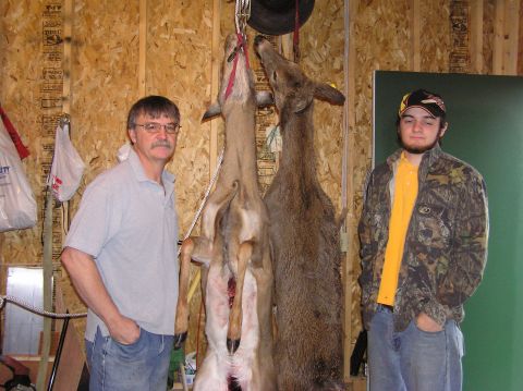 2000 Chevrolet Tahoe - Two men pose with two deer that have been harvested and are hanging for processing.