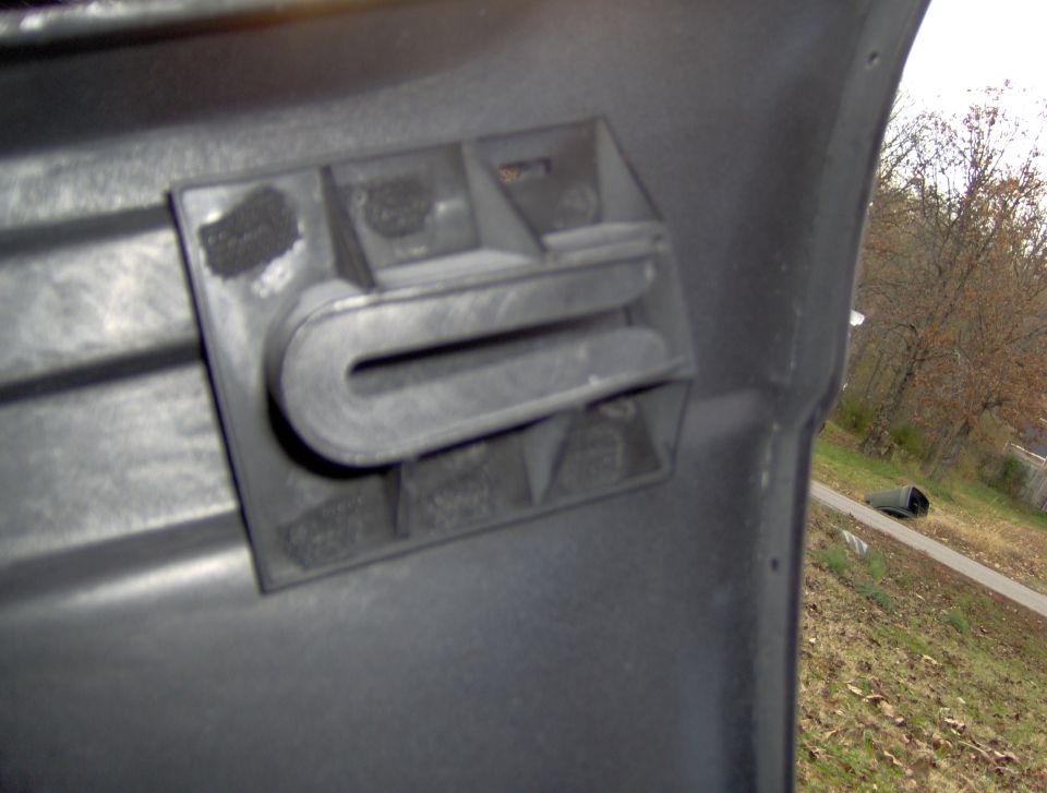 Close-up of a black plastic vehicle body panel with vent