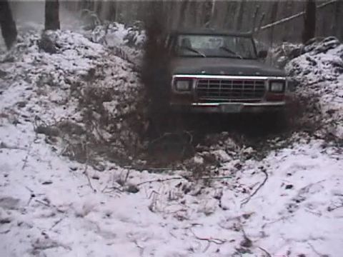 1979 Ford Bronco - A 1979 Ford Bronco navigates a snowy incline, kicking up dark exhaust smoke.