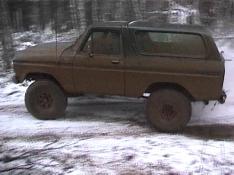 1979 Ford Bronco - A brown 1978 Ford Bronco with a dark top is parked on a snowy path in a wooded area.