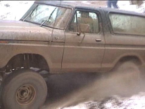 1979 Ford Bronco - This 1979 Ford Bronco is seen in profile, kicking up a cloud of dirt as it drives.