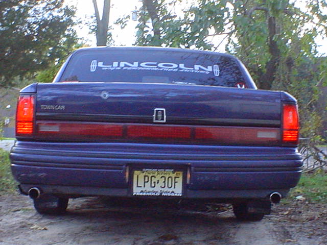 Rear view of blue Lincoln Town Car with NJ plate LPG-30F and Lincoln window banner